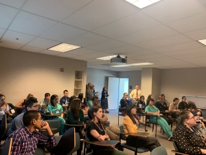 Fellow College conference with row seating in medium conference classroom.